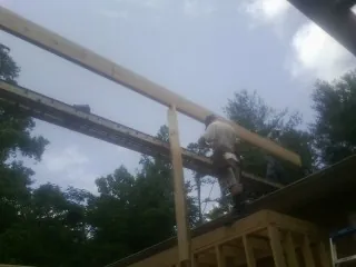 Carpenter setting a ridge beam over a new addition frame — Ice Dam Removal by Roofing Brothers in Greenwood